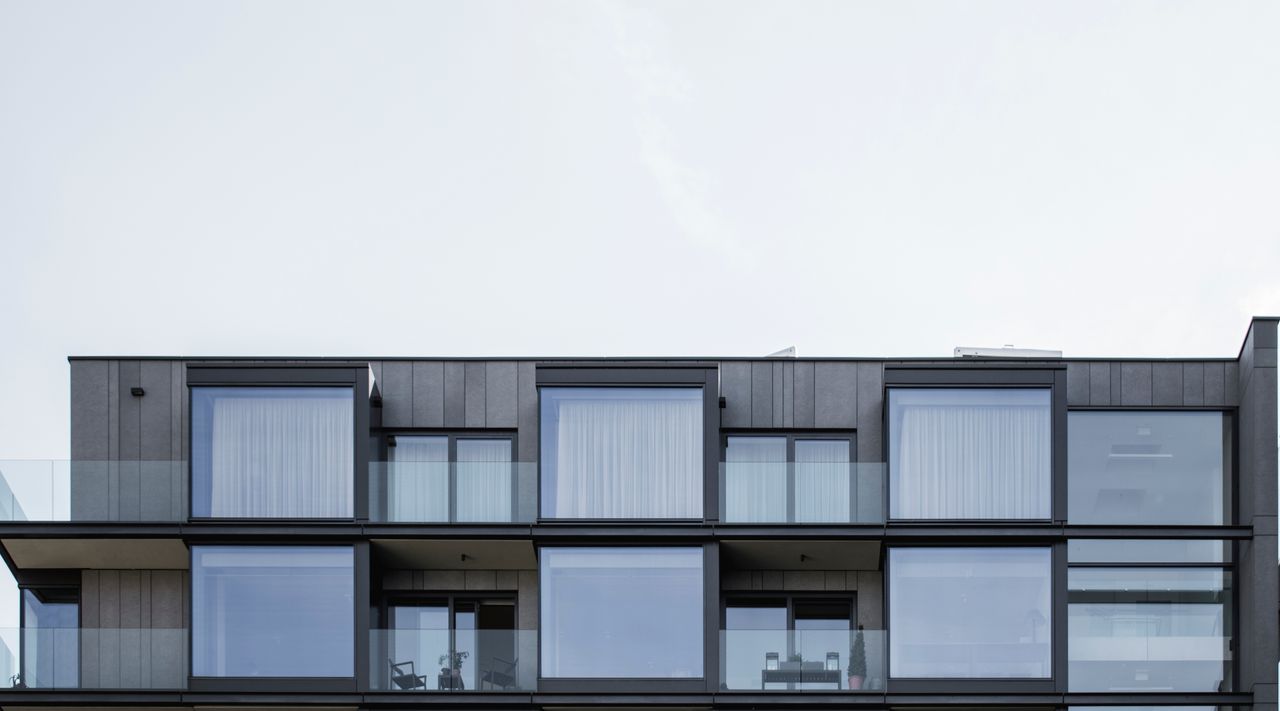 Contemporary apartment facade in Prague featuring glass panels and geometric design.