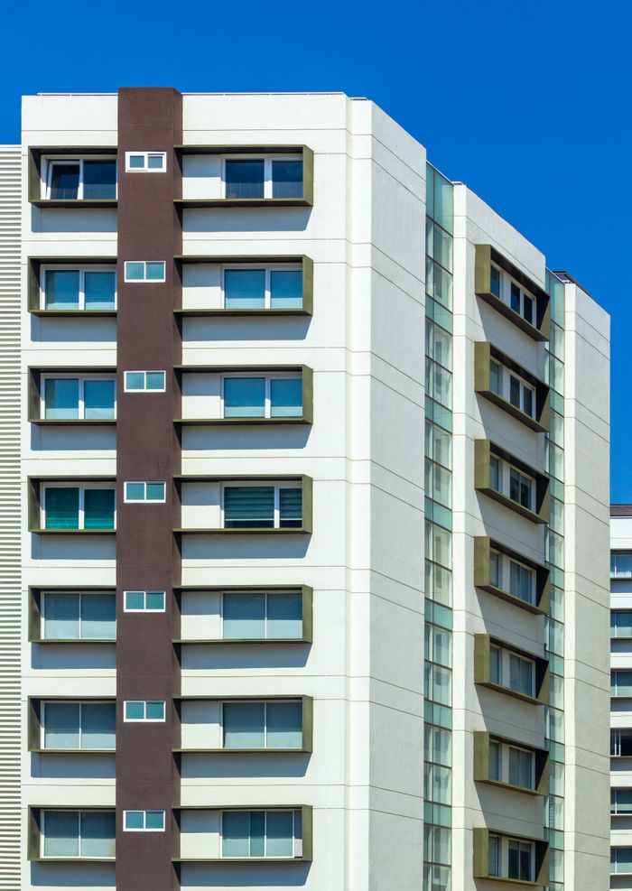 Crafting Captivating Headlines: Your awesome post title goes here Exterior of residential multistory house with white walls with windows located against blue sky in sunlight in daytime in street